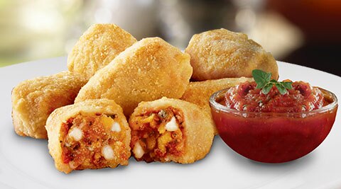 Morningstar Farms Veggie Pepperoni Pizza Bites sit on a plate with dipping sauce.
